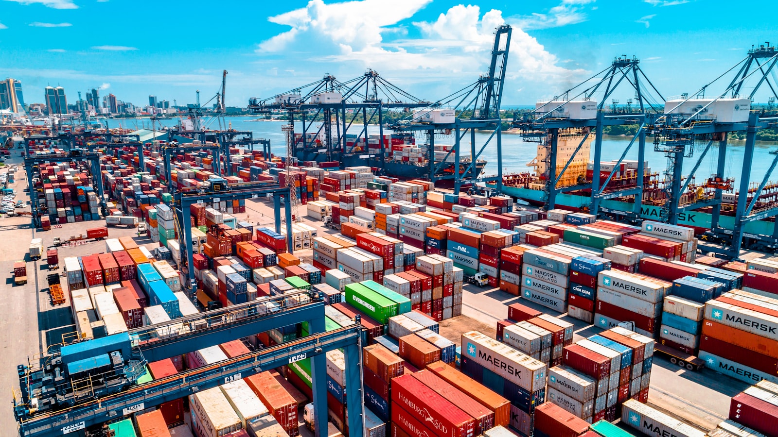 Container port with stacked shipping containers and cranes
